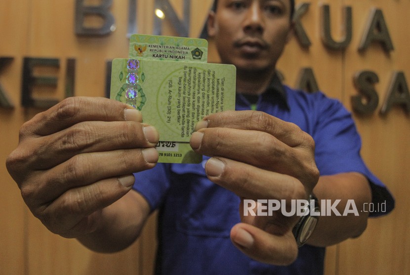 Petugas Kementerian Agama (Kemenag) menunjukan Kartu Nikah di kantor Kemenag, Jakarta, Senin (12/11/2018). 