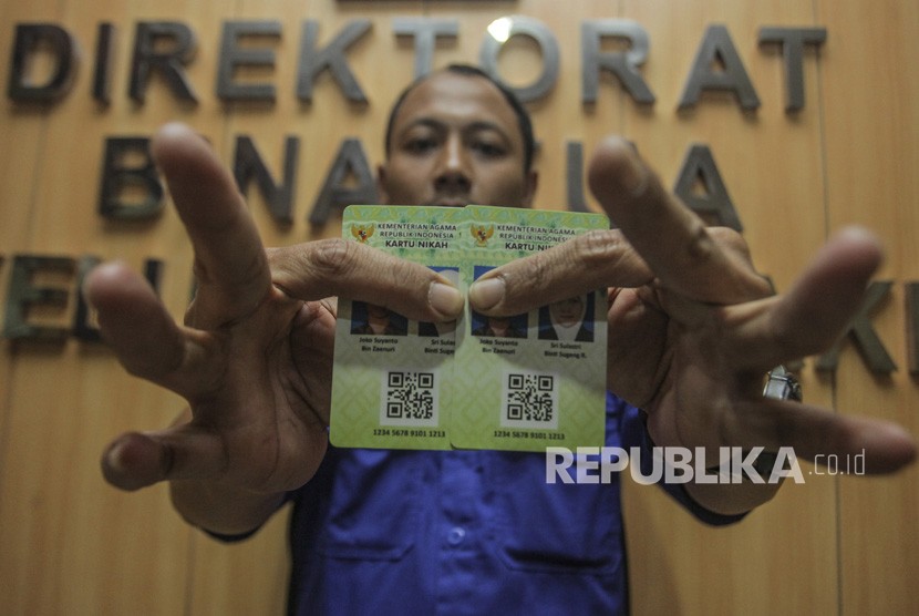 Petugas Kementerian Agama (Kemenag) menunjukan Kartu Nikah di kantor Kemenag, Jakarta, Senin (12/11/2018).