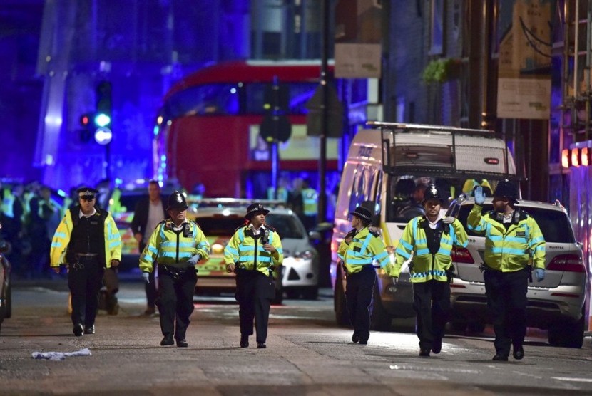 Petugas kepolisian berada di Borough High Street menangani insiden di London Bridge, London, Ahad (4/6) pagi WIB. Saksi mata menyebut satu kendaraan menabrak pedestrian dan mencederai sejumlah orang.