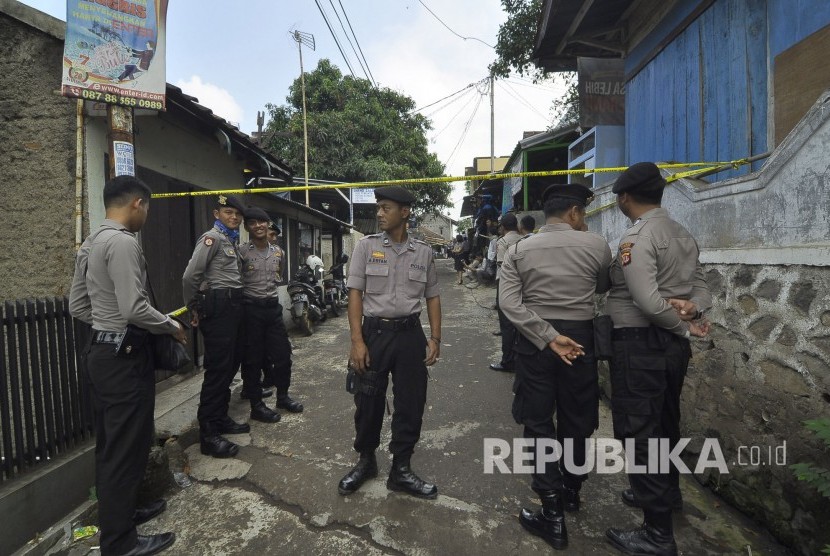 Petugas Kepolisian bergaja saat melakukan memeriksa dan menggeledah sebuah rumah terduga teroris oleh tim Densus 88 di Kampung Paledang, Kecamatan Cileunyi, Kabupaten Bandung, Selasa (6/6).