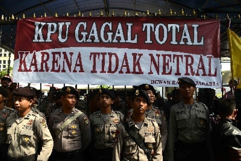 Petugas kepolisian berjada saat aksi demo Dewan Rakyat Jakarta didepan Gedung KPU, Jakarta, Senin (4/8).