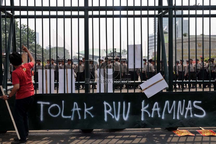  Petugas kepolisian berjaga mengamankan aksi unjukrasa menolak RUU Keamanan Nasional (Kamnas) di depan Kompleks Parlemen, Senayan, Jakarta, Selasa (23/10).  (Tahta Aidilla/Republika)