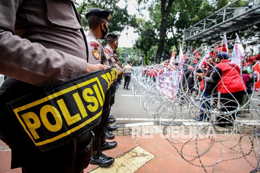 Petugas kepolisian berjaga saat massa dari KSPI berunjuk rasa di Jalan Medan Merdeka Barat, Jakarta, Senin (12/10/2020). Aksi tersebut untuk menolak disahkannya Undang-Undang Cipta Kerja. 