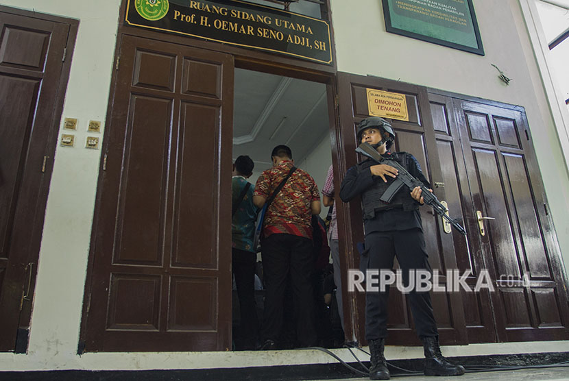 Petugas kepolisian berjaga saat sidang kasus terorisme dengan terdakwa Aman Abdurrahman alias Oman Rochman alias Abu Sulaiman bin Ade Sudarma di PN Jakarta Selatan, Jakarta, Jumat (18/5). 