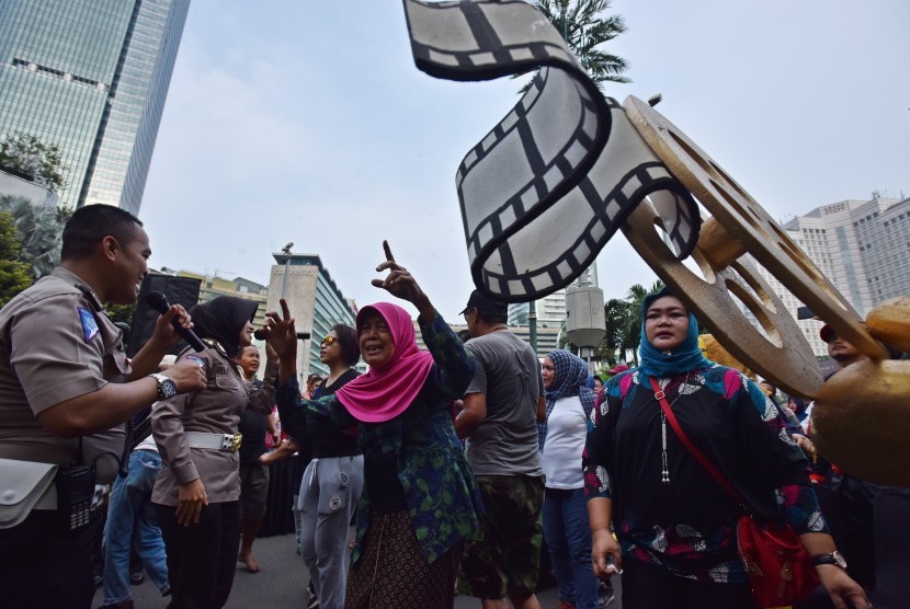 Petugas kepolisian berjoget bersama warga ketika peluncuran Police Movie Festival 4 di Kawasan Bundaran HI Jakarta, 16 April 2017. Festival film pendek dan film animasi tentang Kepolisian bertajuk Police Movie Festival dengan tema Unity and Diversity itu untuk memperingati HUT ke-72 Polri.