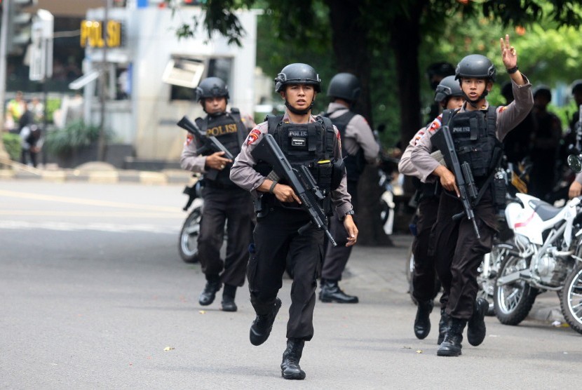 Petugas kepolisian berlari ke arah gedung Sarinah untuk melakukan pengejaran terhadap pelaku penyerangan yang dilakukan sejumlah teroris ke beberapa gedung dan pos polisi di Jakarta, Kamis (14/1). 