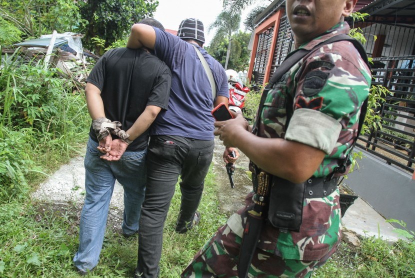 Petugas kepolisian berpakaian sipil bersama prajurit TNI menangkap salah satu tahanan yang kabur dari Rutan Sialang Bungkuk Kelas IIB, Pekanbaru, Riau, Jumat (5/5). 