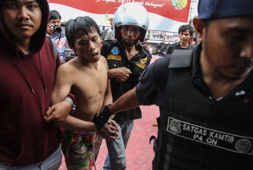 Petugas kepolisian berpakaian sipil menangkap salah satu tahanan yang kabur dari Rutan Sialang Bungkuk Kelas IIB, Pekanbaru, Riau, Jumat (5/5).