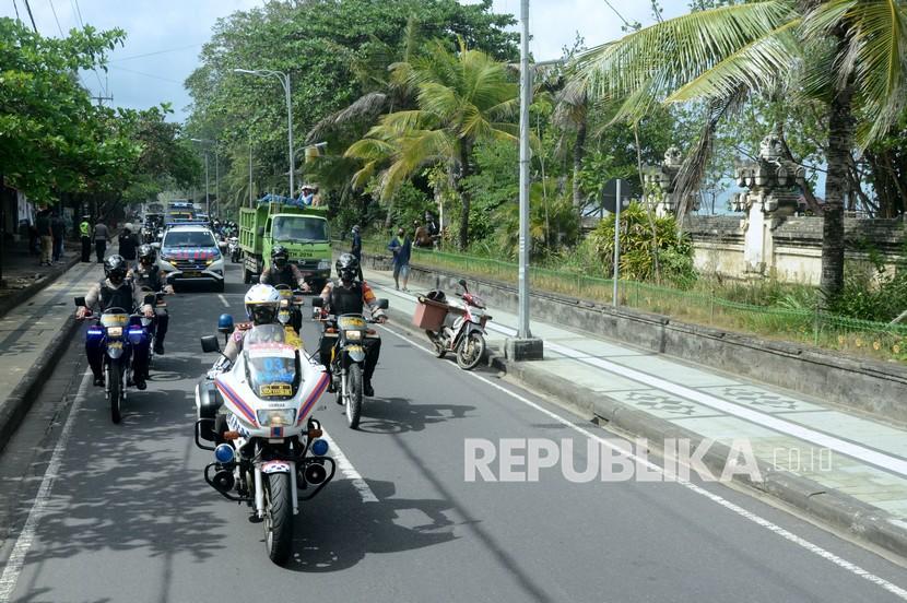 Petugas kepolisian berpatroli di jalur akses kawasan wisata Kuta, Badung, Bali di tengah penerapan kebijakan  PPKM.