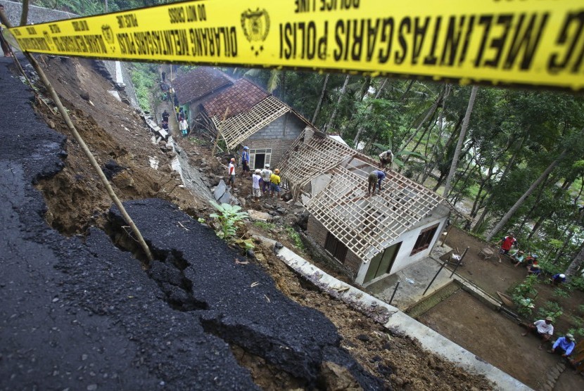 Petugas kepolisian bersama Tagana dan masyarakat membersihkan puing rumah yang tertimpa longsoran tanah di Kluwih, Pendoworejo, Kulonprogo, DI Yogyakarta, Rabu (16/12). (Antara/Andreas Fitri Atmoko)