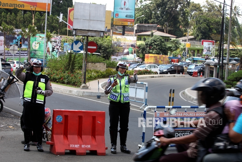 Petugas kepolisian bersiap melakukan rekayasa lalu lintas untuk mencegah kemacetan kendaraan menuju Puncak, Bogor, Jawa Barat.  (Republika/Rakhmawaty La'lang)
