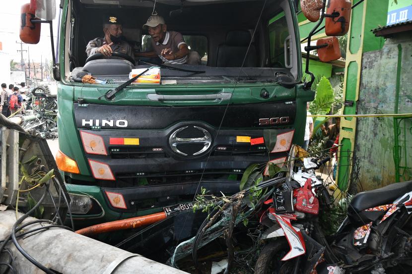 Kepolisian berusaha mengevakuasi sebuah truk kontainer yang menabrak halte bus di depan SDN Kota Baru II dan III di Jalan Sultan Agung, Kota Bekasi, Jawa Barat, Rabu (31/8/2022). 