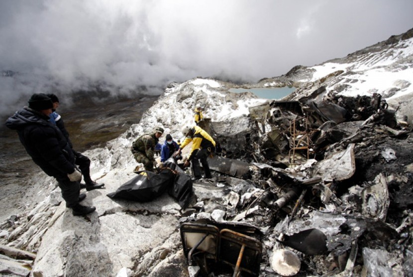  Petugas kepolisian dan petugas penyelamat melakukan evakuasi korban kecelakaan helikopter di Gunung Mama Rosa di Ocongate, Peru, 10 Juni 2012. 