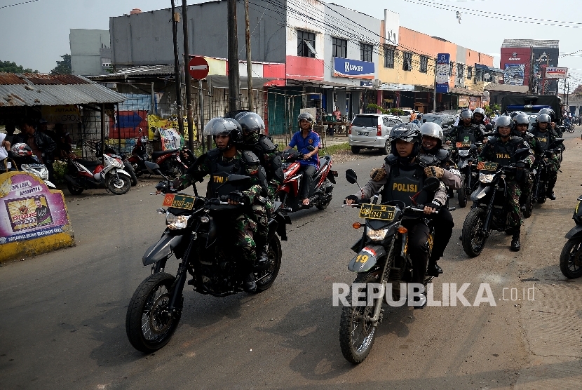 Petugas kepolisian dan TNI melakukan patroli di kawasan Sangiang, Tangerang, Banten, Kamis (9/3).