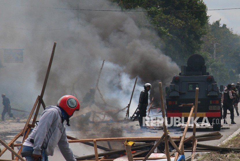 Petugas kepolisian dan TNI melakukan penjagaan saat massa aksi menutup jalan di Mimika, Papua, Rabu (21/8/2019). 