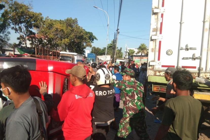Petugas kepolisian dan TNI serta warga bergotong royong evakuasi microbus yang terguling di jalan raya pantura Kecamatan Besuki, Situbondo, Jawa Timur. Sabtu (23/9/2023).