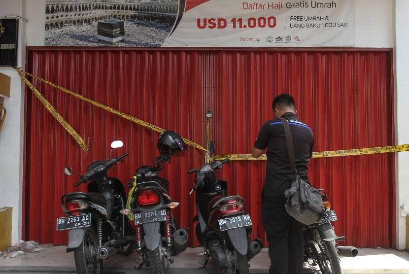 Petugas Kepolisian Direktorat Kriminal Khusus Polda Riau menyegel Kantor cabang keberangkatan haji dan umrah Abu Tours di Pekanbaru, Riau, Selasa (17/4). 