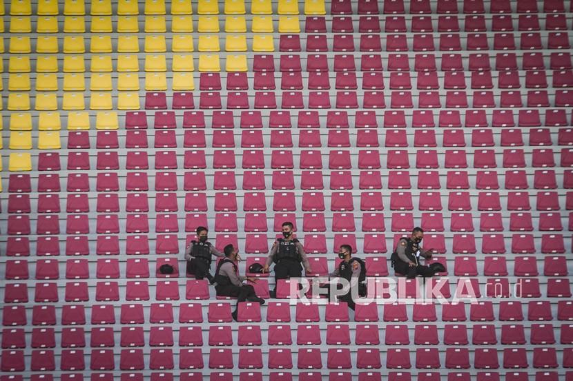 Petugas kepolisian duduk di kursi tribun penonton yang kosong saat pertandingan Piala Menpora di Stadion Manahan, Solo, Jawa Tengah, Ahad (21/3/2021). Piala Menpora dengan pertandingan pembuka Arema FC melawan Persikabo 1973 dilaksanakan tanpa penonton dan menerapkan protokol kesehatan ketat. 