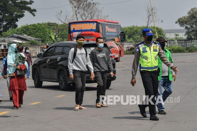 Petugas Kepolisian (kanan) mengarahkan sejumlah pemudik untuk mengikuti rapid antigen di Terminal Kalijaya, Cikarang, Kabupaten Bekasi. Dishub Jawa Barat mengecek kelaikan armada angkutan mudik di Terminal Cikarang.