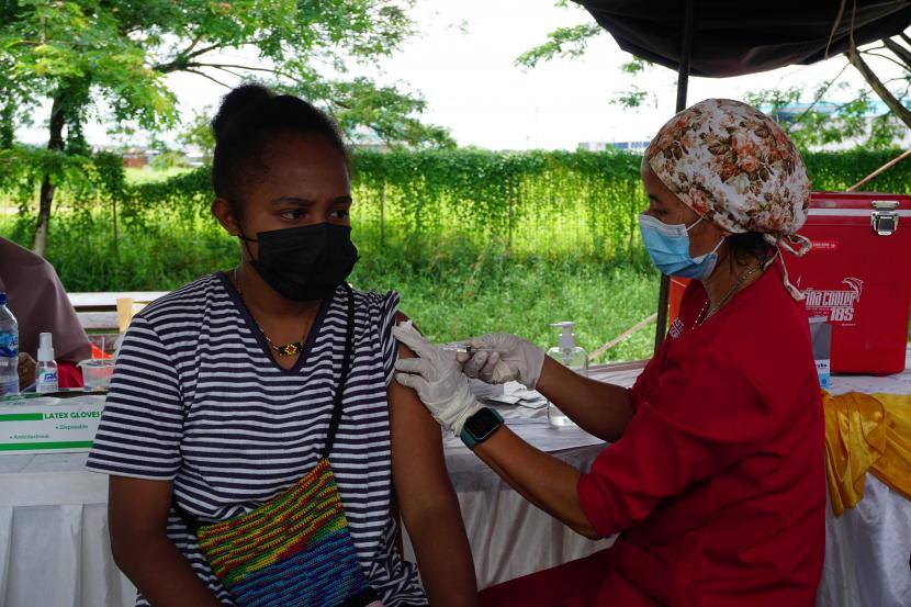 Petugas Kepolisian (kanan) menyuntikan vaksin COVID-19 kepada wraga di gerai vaksinasi di Taman Sorong City depan Bandara DEO Kota Sorong, Papua Barat, Senin (13/12/2021). Peprov Papua Barat dan pihak kepolisian melakukan percepatan vaksin COVID-19 dengan memperbanyak gerai vaksinasi di area publik untuk mencapai target 70 persen vaksinasi pada tahun 2021 karena capain Vaksinasi COVID-19 di Papua Barat hingga saat ini baru mencapai 47,6 persen untuk dosis pertama dan 28,6 persen untuk dosis kedua.