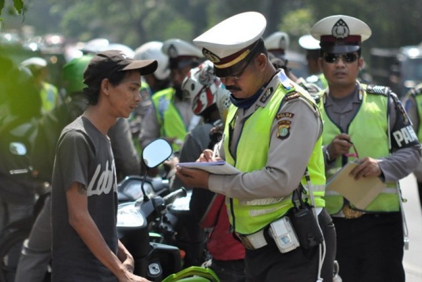 Petugas kepolisian lalu lintas menindaki seorang pengendara sepeda motor pada Operasi Zebra Jaya 2012 di Kawasan Pasar Rebo, Jakarta Timur, Jumat (30/11).