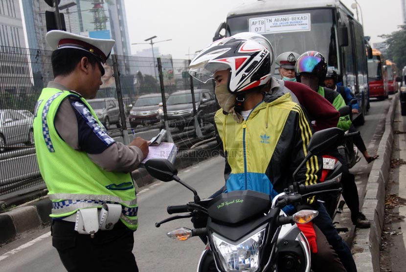   Petugas kepolisian melaksanakan operasi penertiban di jalur Bus Transjakarta kawasan Jalan MT. Haryono, Jakarta Selatan, Rabu (26/3).  (Republika/Yasin Habibi)