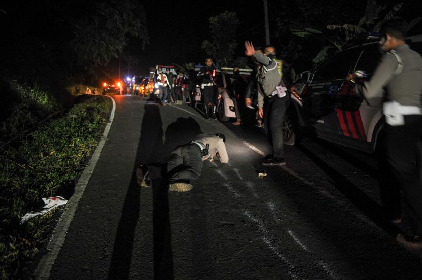 Petugas kepolisian melakukan olah TKP di area kecelakaan bus PO Sri Padma Kencana di Wado, Kabupaten Sumedang, Jawa Barat, Rabu (10/3/2021). Hingga Rabu (10/3) malam, petugas kepolisian mencatat sebanyak 22 orang meninggal dunia dalam kecelakaan tersebut dan 28 korban selamat dilarikan ke RSUD Kabupaten Sumedang. 