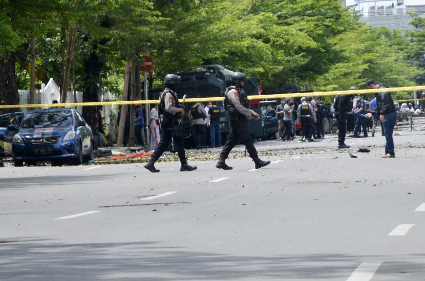 Petugas kepolisian melakukan pemeriksaan di sekitar sisa-sisa ledakan dugaan bom bunuh diri di depan Gereja Katolik Katedral, Makassar, Sulawesi Selatan, Ahad (28/3/2021). Ledakan bom di gereja tersebut mengakibatkan dua korban tewas yang diduga pelaku bom bunuh diri serta melukai 14 orang jemaat dan petugas gereja. 