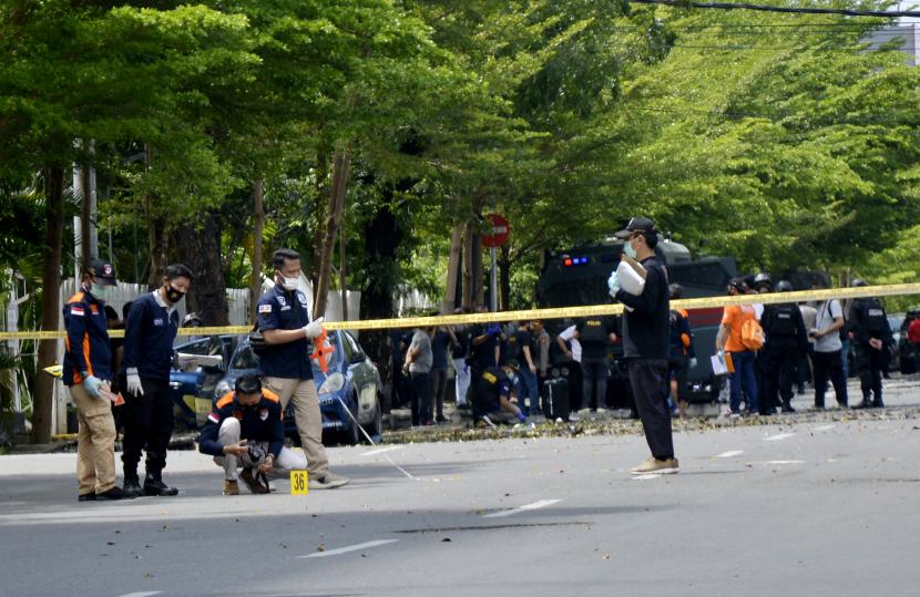 Petugas kepolisian melakukan pemeriksaan di sekitar sisa-sisa ledakan dugaan bom bunuh diri di depan Gereja Katolik Katedral, Makassar, Sulawesi Selatan, Ahad (28/3/2021). Ledakan bom di gereja tersebut mengakibatkan dua korban tewas yang diduga pelaku bom bunuh diri serta melukai 14 orang jemaat dan petugas gereja.