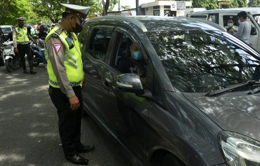 Petugas kepolisian melakukan pemeriksaan kelengkapan surat kendaraan. 