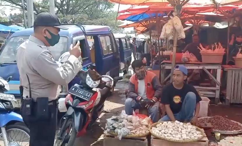 Petugas kepolisian melakukan pendisiplinan protokol kesehatan kepada masyarakat di Pasar Kranggot, Kota Cilegon.