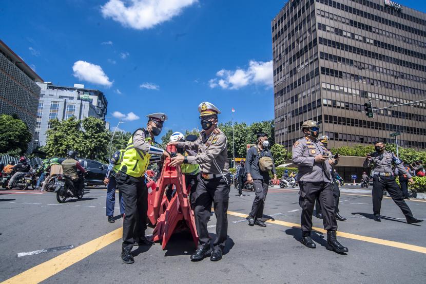Petugas kepolisian melakukan penyekatan jalan untuk mengantisipasi membludaknya massa reuni 212 di kawasan Sarinah Thamrin, Jakarta, Kamis (2/12/2021). Pihak kepolisian melakukan penyekatan disejumlah wilayah karena pelaksanaan reuni 212 dapat meningkatkan risiko penyebaran virus COVID-19. 