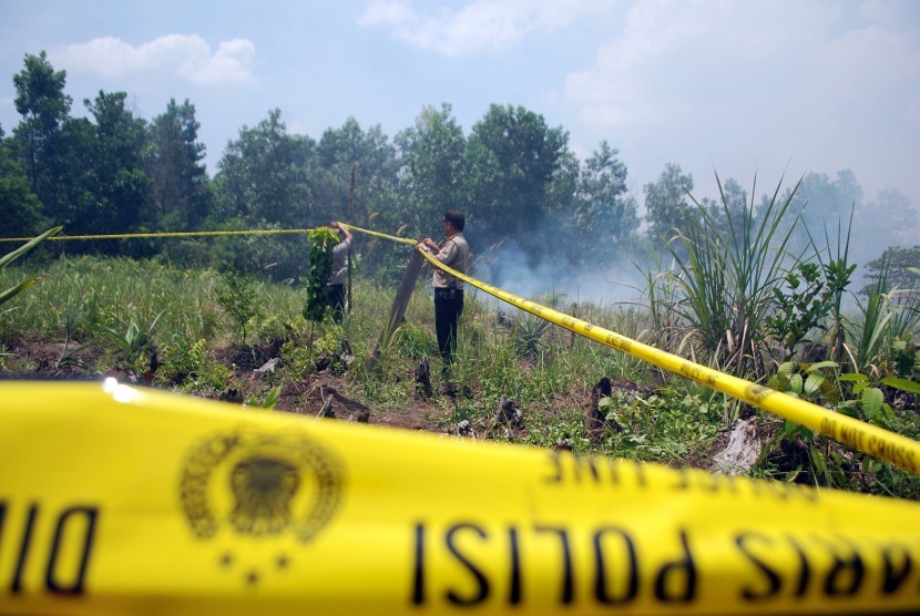 Petugas Kepolisian memasang garis polisi guna penyelidikan di lokasi yang terbakar di Pekanbaru, Riau, Rabu (10/8).