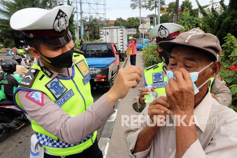 Petugas kepolisian meminta pengendara memakai masker (ilustrasi).