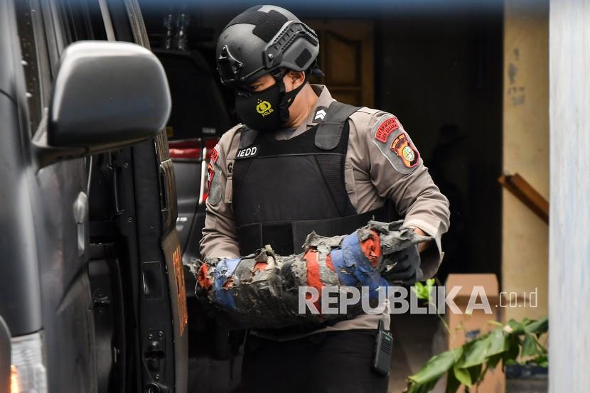 Petugas Kepolisian membawa barang bukti usai penggeledahan rumah terduga teroris di Serang Baru, Kabupaten Bekasi, Jawa Barat, Senin (29/3). Tim Detasemen Khusus (Densus) 88 Antiteror Polri mengamankan barang bukti bahan peledak dan bom rakitan untuk proses penyelidikan. 