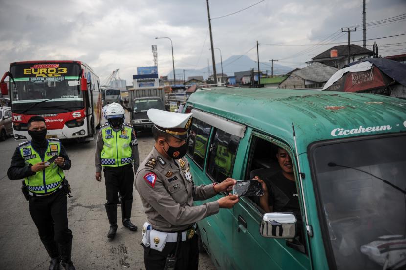 Petugas kepolisian memberikan masker kepada sopir angkutan kota saat operasi kepatuhan memakai masker di Posko Lantas Tangguh (ilustrasi).