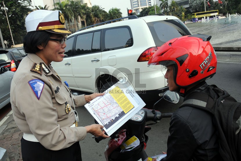 Petugas kepolisian memberikan sosialisasi tentang pengalihan arus lalu lintas saat hari pengumuman rekapitulasi suara Pilpres 2014-2019 di kawasan Bundaran HI, Jakarta, Jumat (18/7). (Republika/Aditya Pradana Putra)