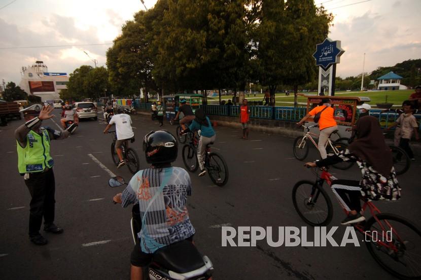 Petugas kepolisian membubarkan warga yang berkumpul di Alun-alun Kota Tegal, Jawa Tengah, Sabtu (11/4/2020). Polres Tegal Kota berpatroli memberikan imbauan kepada masyarakat untuk menggunakan masker jika bepergian dan menertibkan warga yang berkerumun untuk mencegah penyebaran COVID-19. 