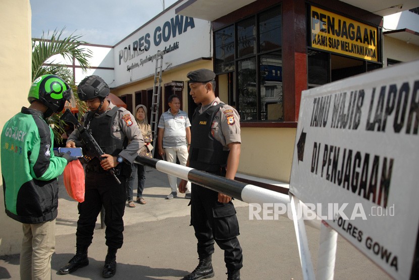 Petugas kepolisian memeriksa barang pengemudi ojek online yang akan masuk mengantar pesanan di Polres Kabupaten Gowa, Sulawesi Selatan, Rabu (13/11/2019). 