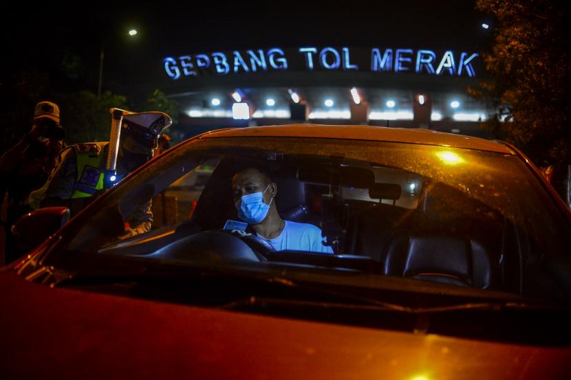 Petugas kepolisian memeriksa identitas dari pengendara mobil yang keluar dari Gerbang Tol Merak di Cilegon, Banten.