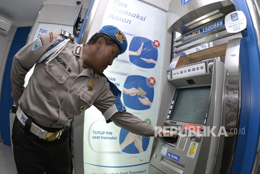 Petugas kepolisian memeriksa mesin Anjungan Tunai Mandiri (ATM). (ilustrasi)