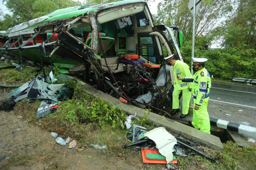 Petugas kepolisian memeriksa sebuah bus yang mengalami kecelakaan di Imogiri, Bantul, DI Yogyakarta, Ahad (6/2/2022). Hingga Ahad (6/2) malam, petugas kepolisian mencatat sebanyak 13 orang meninggal dunia dalam kecelakaan tersebut. 