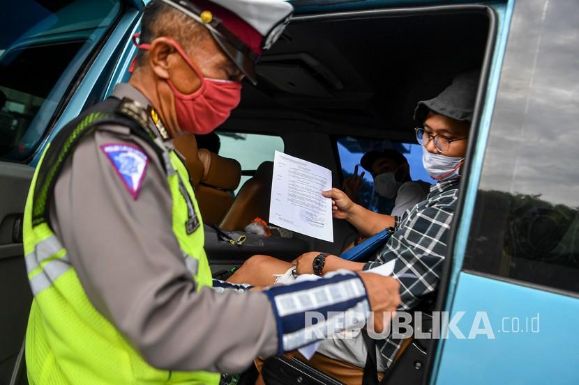 Petugas kepolisian memeriksa sejumlah kendaraan yang melintas di jalan tol Jakarta-Cikampek, Cikarang Barat, Jawa Barat. 