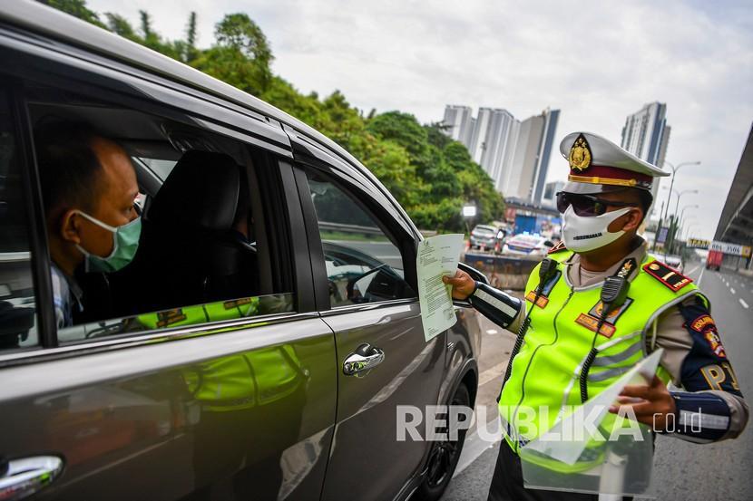 Petugas kepolisian memeriksa sejumlah kendaraan yang melintas di jalan tol Jakarta-Cikampek.