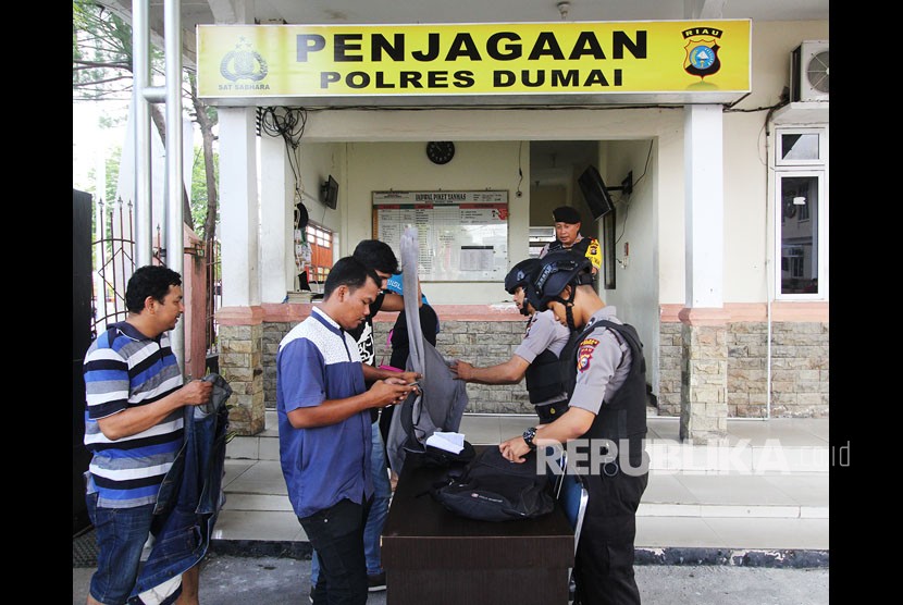 Petugas kepolisian memeriksa semua barang bawaan pengunjung di Markas Kepolisian Resor (Mapolres) Dumai di kota Dumai, Dumai, Riau, Senin (14/5). 