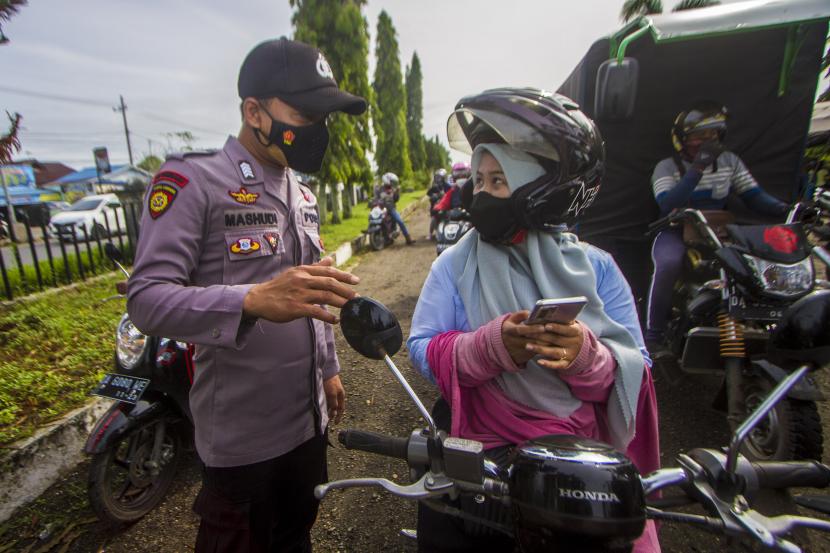 Petugas kepolisian memeriksa sertifikat vaksin pengendara motor yang melintas di jalan Ahamad Yani, Banjarbaru, Kalimantan Selatan, Selasa (28/12/2021). Mahkamah Konstitusi dalam putusannya, Rabu (26/1/2022) polisi tetap sah memeriksa identitas warga saat razia. (ilustrasi)