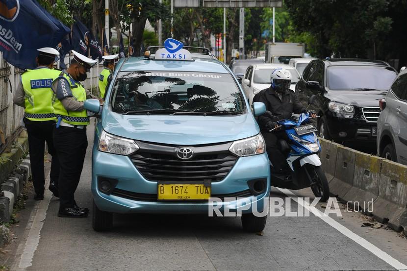 Petugas kepolisian memeriksa surat-surat pengendara yang memasuki jalur khusus Transjakarta saat Operasi Zebra Jaya di Jalan Arteri Pondok Indah, Jakarta, Senin (15/11/2021).