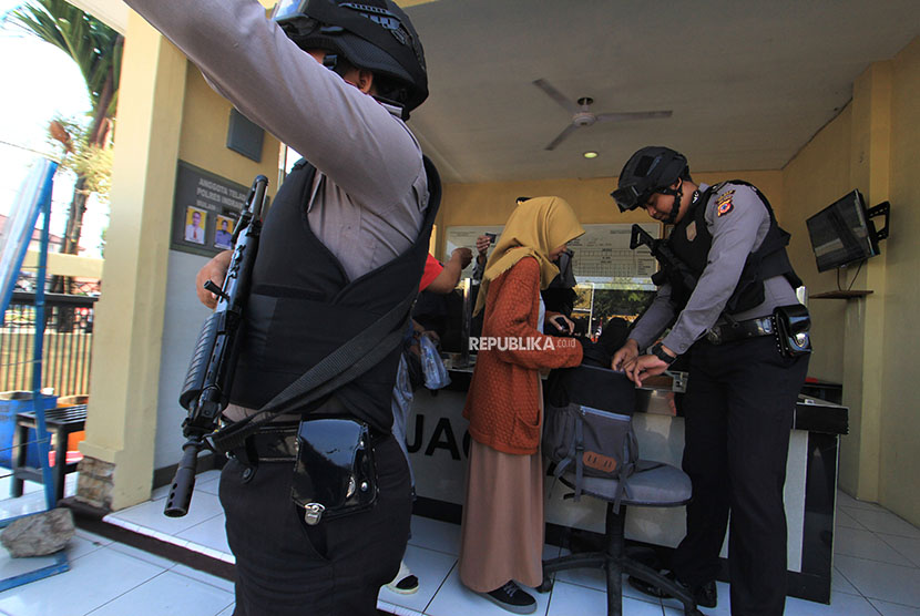 Petugas kepolisian memeriksa warga yang akan masuk ke Mapolres Indramayu, Jawa Barat, Senin (14/5). Penjagaan ketat di sejumlah tempat dilakukan aparat kepolisian menyusul ledakan bom di Surabaya.