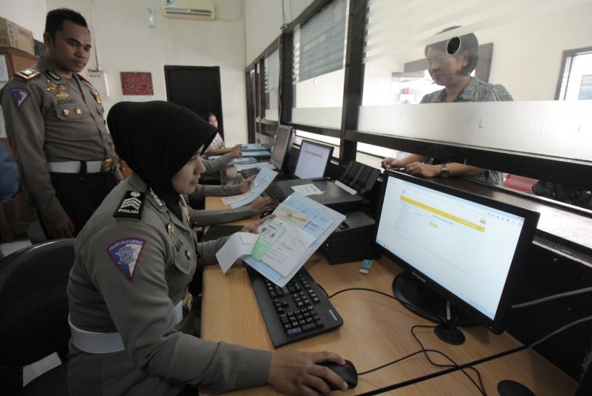 Petugas kepolisian memperagakan proses perpanjangan Surat Ijin Mengemudi (SIM) secara daring (online) di Satpas Colombo Surabaya. (ilustrasi)