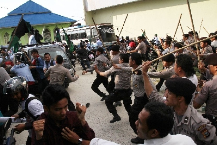 Petugas kepolisian memukul mundur pengunjukrasa yang ingin menguasai kantor RRI di halaman kantor Radio Republik Indonesia (RRI) di Pekanbaru, Riau,